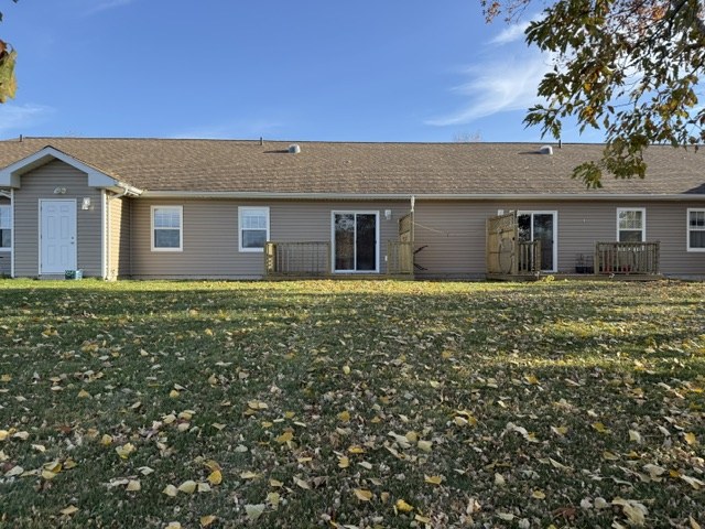 Back of the condo building across a leaf-covered lawn