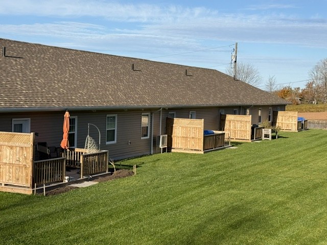 Rear patios with privacy screens facing a large lawn